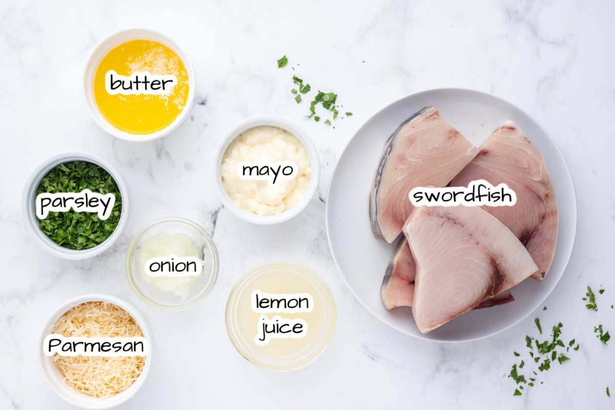 Swordfish parmesan with a golden, savory topping. An easy, fresh seafood dinner ready in under 30 minutes! ingredients displayed for making swordfish parmesan