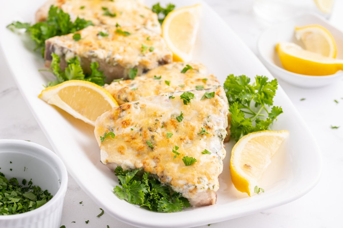 Swordfish parmesan with a golden, savory topping. An easy, fresh seafood dinner ready in under 30 minutes! swordfish parmesan on platter with lemon wedges