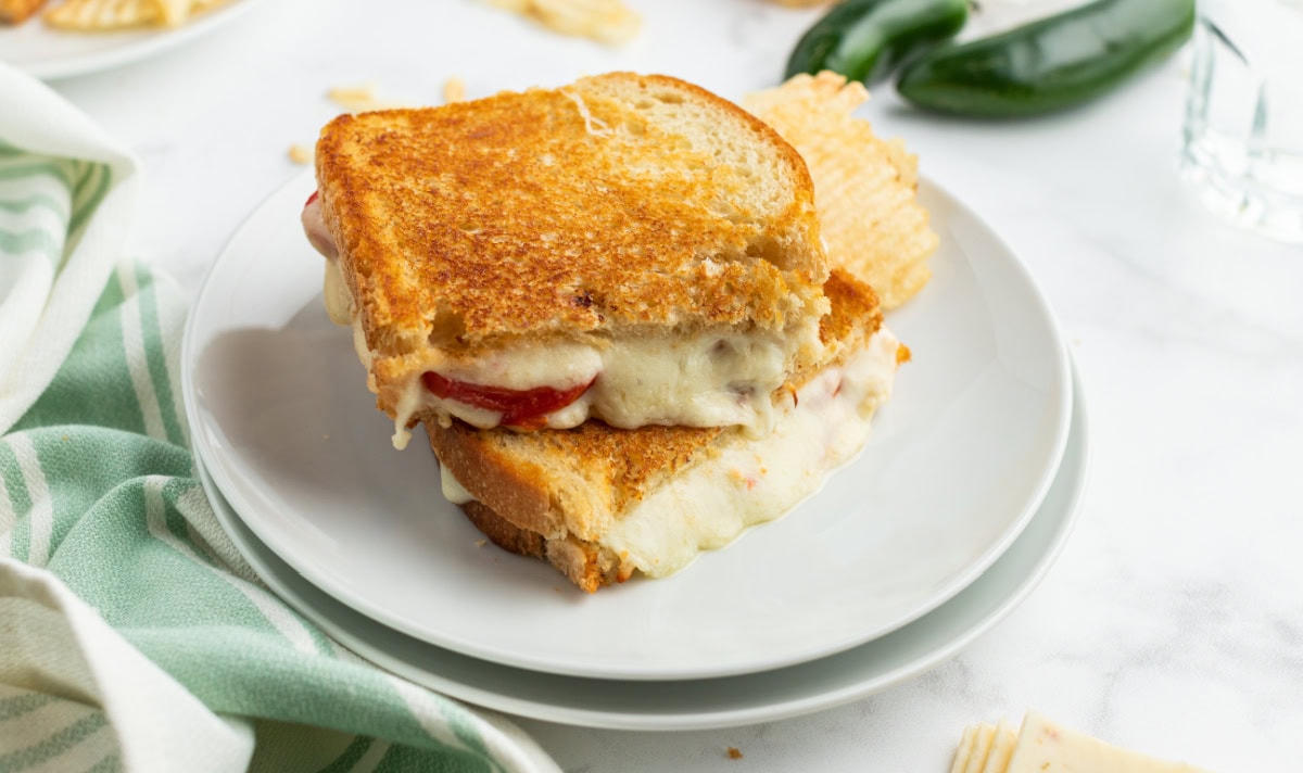 two halves of a tomato grilled cheese on plate