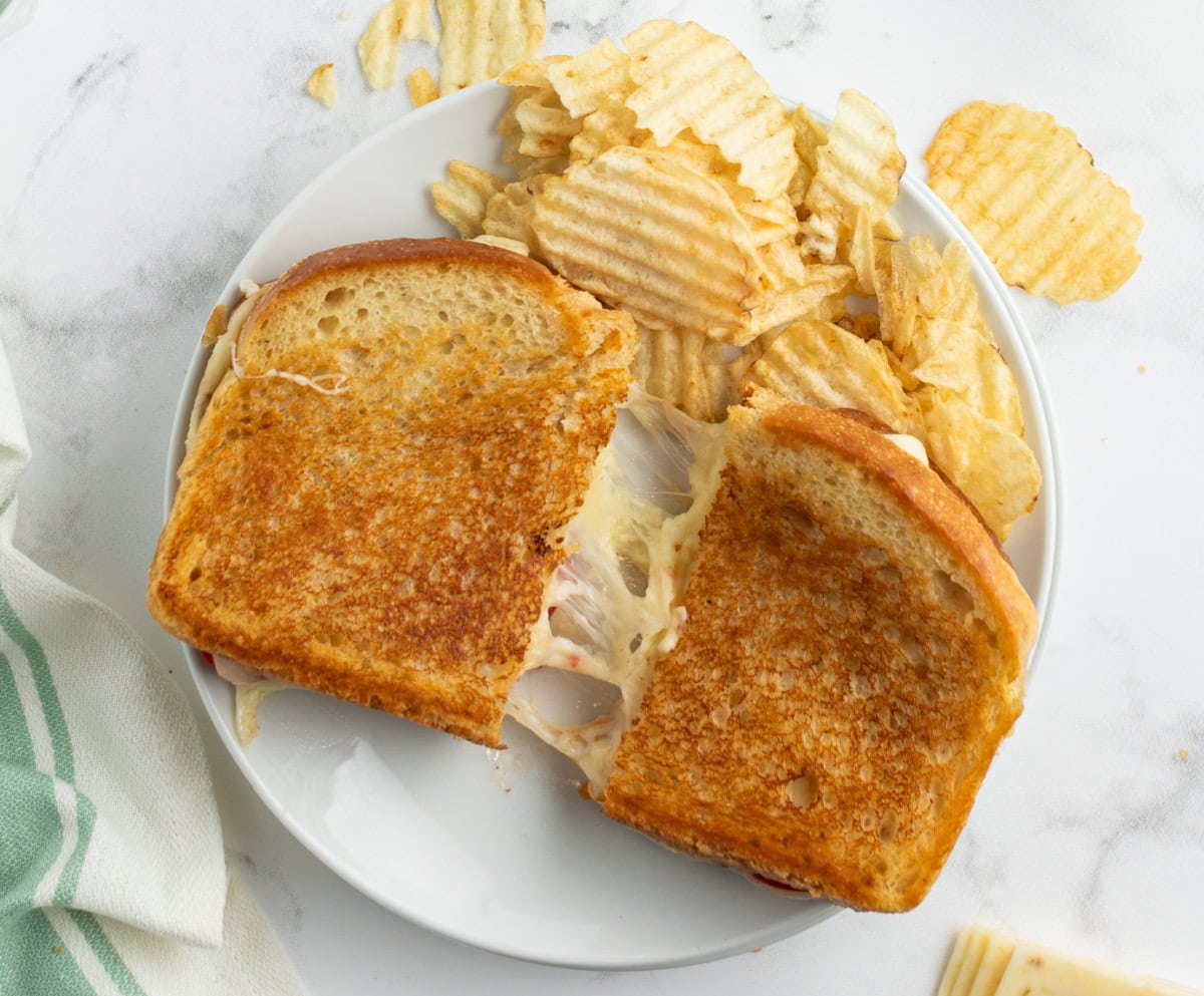 tomato grilled cheese on a plate with chips