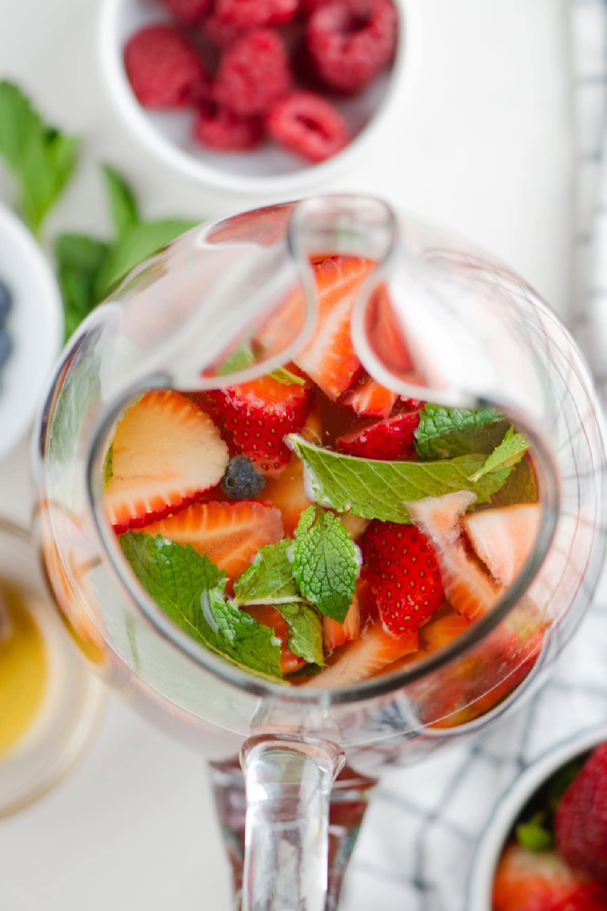 Berry iced tea sangria with white wine, fresh berries and honey. Light, refreshing and perfect for summer! overhead shot of pitcher of berry iced tea sangria