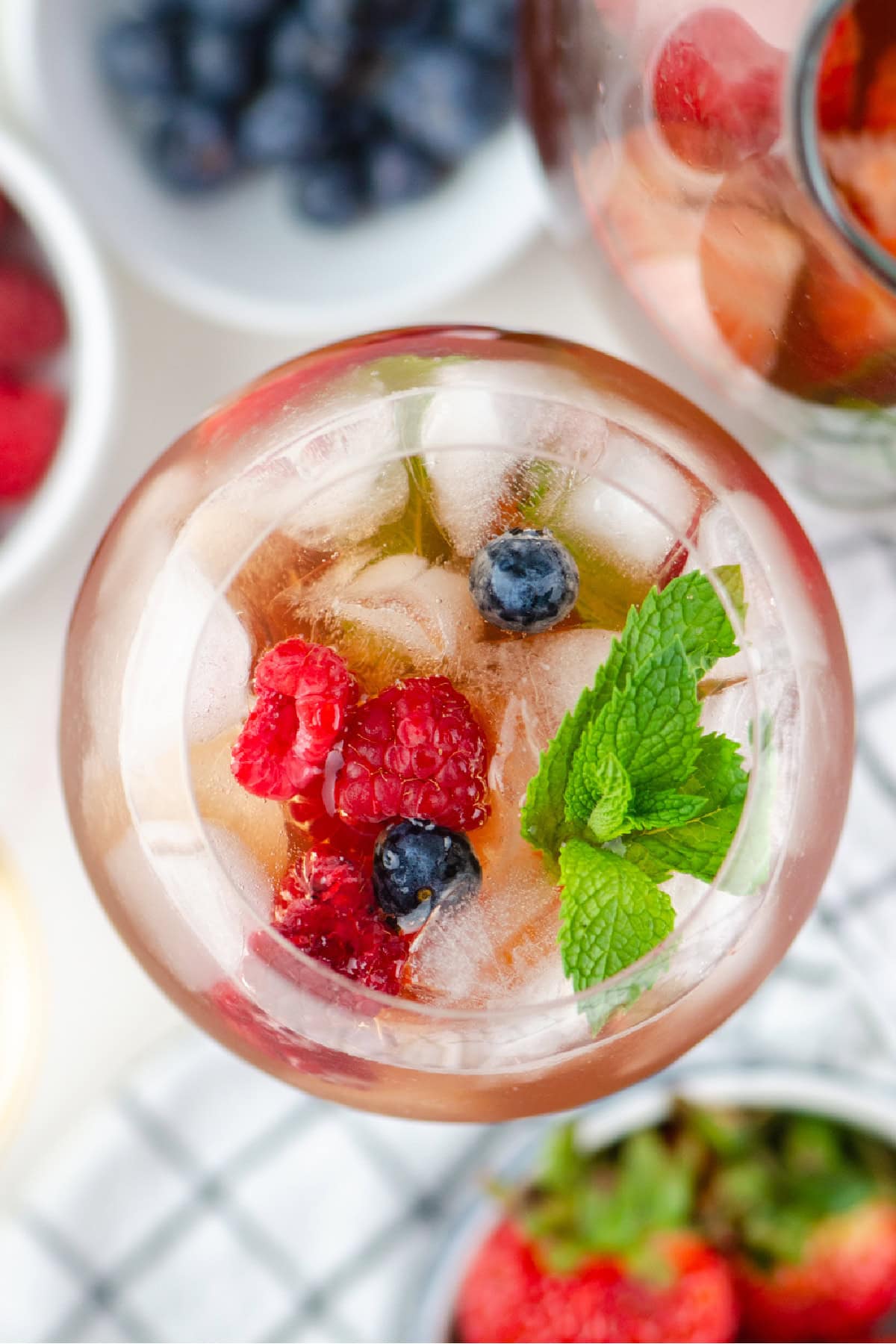 Berry iced tea sangria with white wine, fresh berries and honey. Light, refreshing and perfect for summer! overhead shot of glass of berry iced tea sangria