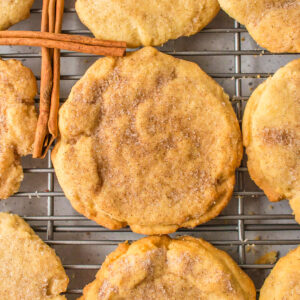 sugar and cinnamon cookies on a cooling rack with cinnamon sticks