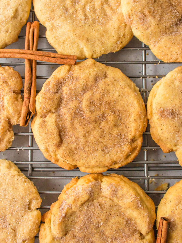 sugar and cinnamon cookies on a cooling rack with cinnamon sticks