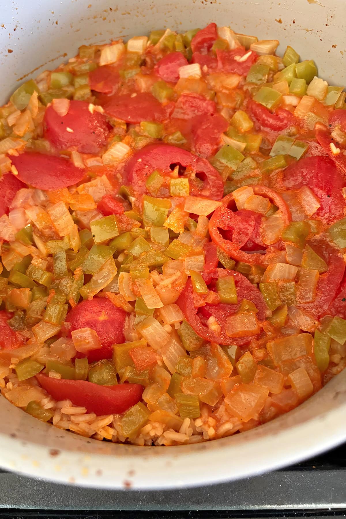 This easy Arroz con Pollo is a flavorful one-pan chicken and rice dinner that's ready in only 45 minutes! Made with juicy chicken, rice, tomatoes and peppers, it's the perfect family-friendly weeknight meal. arroz con pollo cooked in the pan