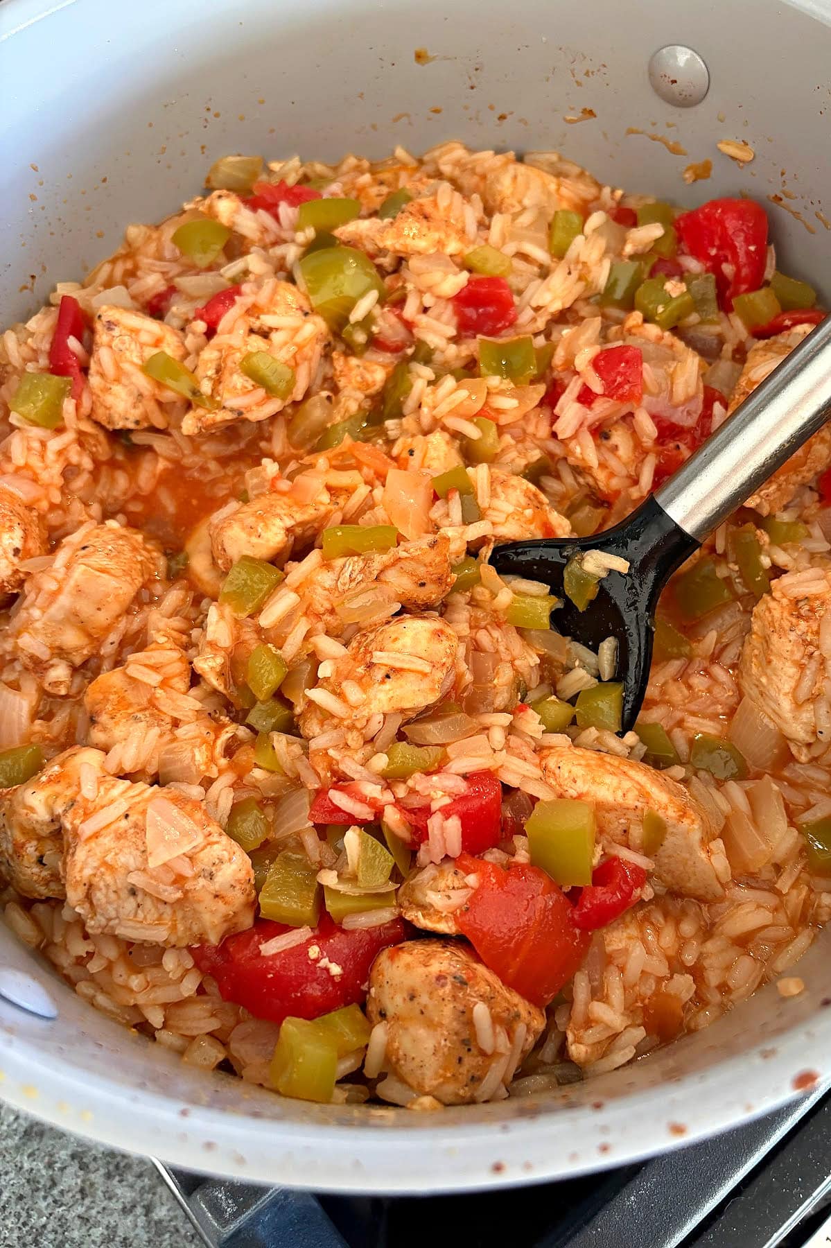 This easy Arroz con Pollo is a flavorful one-pan chicken and rice dinner that's ready in only 45 minutes! Made with juicy chicken, rice, tomatoes and peppers, it's the perfect family-friendly weeknight meal. arroz con pollo in skillet