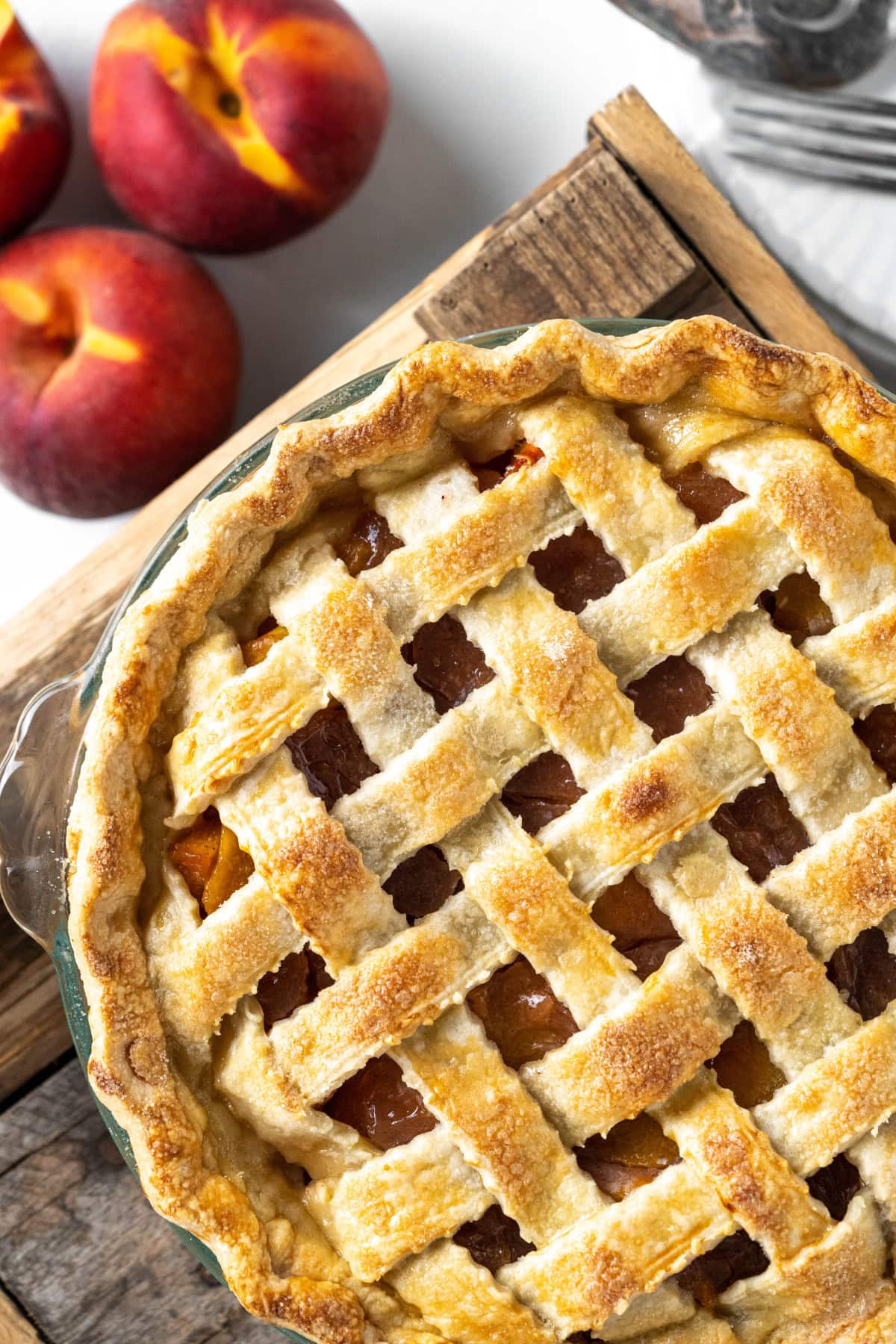 This Fresh Peach Pie Recipe is everything summer baking should be! 🍑 Made with juicy ripe peaches, a flaky homemade butter crust and a gorgeous lattice top, this classic pie is perfect for holidays, BBQs and family gatherings. Save this recipe for peach season! #peachpie #freshpeaches #summerdesserts #pierecipe #homemadepie fresh peach pie recipe with lattice top crust