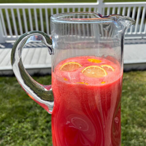 pitcher of watermelon strawberry lemonade in backyard