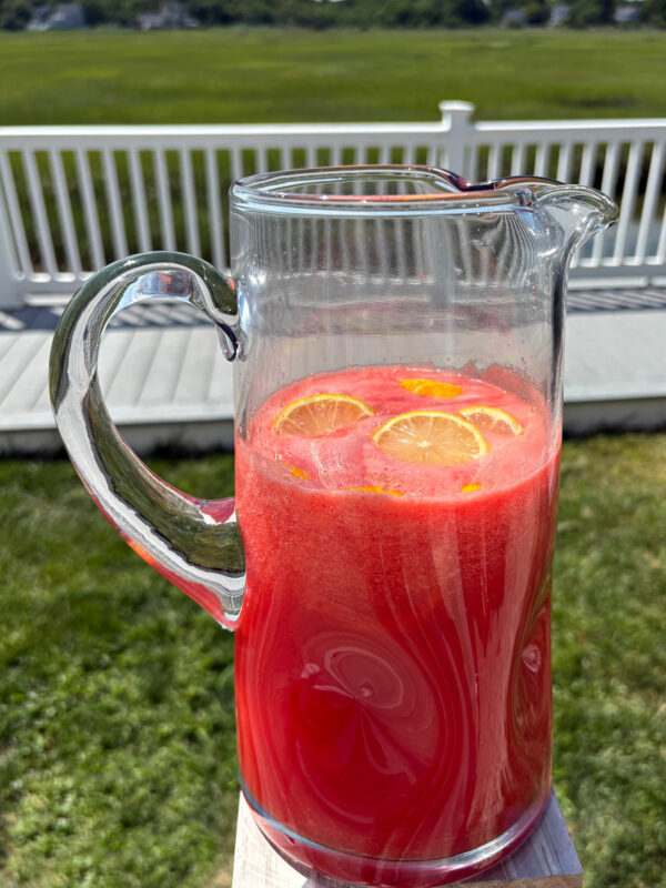 pitcher of watermelon strawberry lemonade in backyard