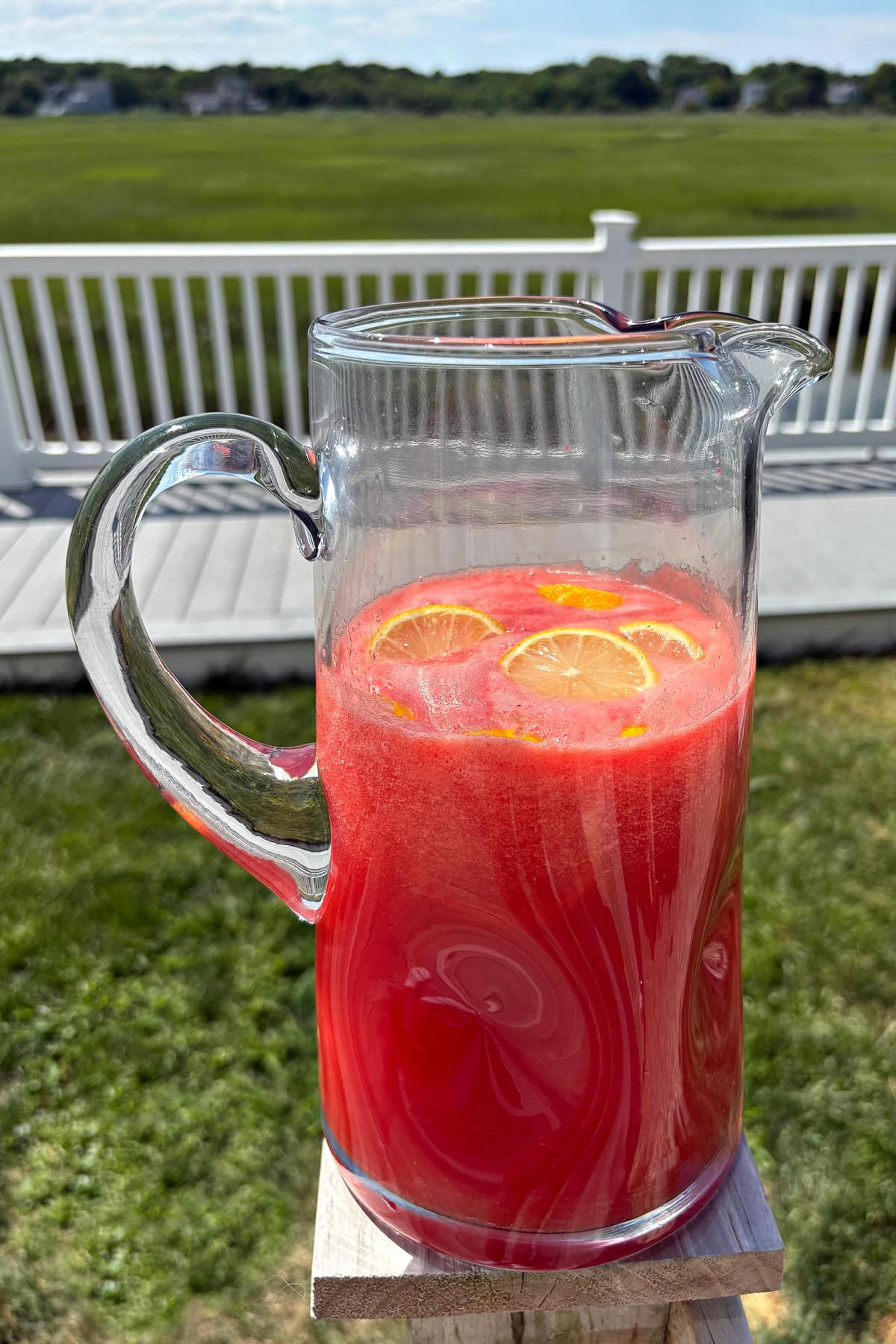 pitcher of watermelon strawberry lemonade in backyard