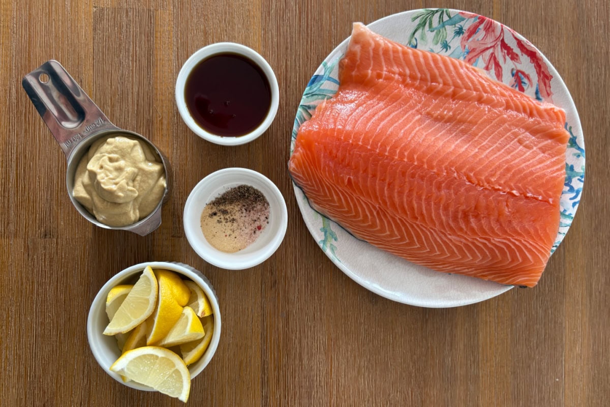 This Maple Mustard Salmon is one of the easiest salmon dinners you'll ever make! 🍁 Made with Dijon mustard, pure maple syrup and garlic, it's sweet, savory, flaky and perfect for busy weeknights or entertaining. Save this easy baked salmon recipe! #salmon #salmonrecipe #healthydinner #weeknightdinner #seafood ingredients displayed for making maple mustard salmon