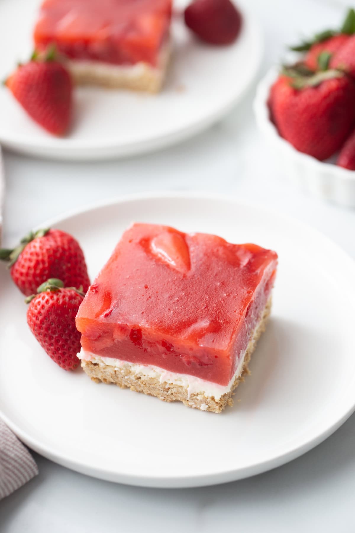 This Old Fashioned Strawberry Pretzel Salad is a timeless favorite! 🍓 Made with a buttery pretzel crust, fluffy cream cheese layer and a homemade strawberry topping with real strawberries, it's the perfect make-ahead dessert for holidays, potlucks and summer parties. Save this classic recipe! #strawberrypretzelsalad #strawberrydessert #potluckrecipes #summerdesserts #vintagerecipes strawberry pretzel salad piece on plate