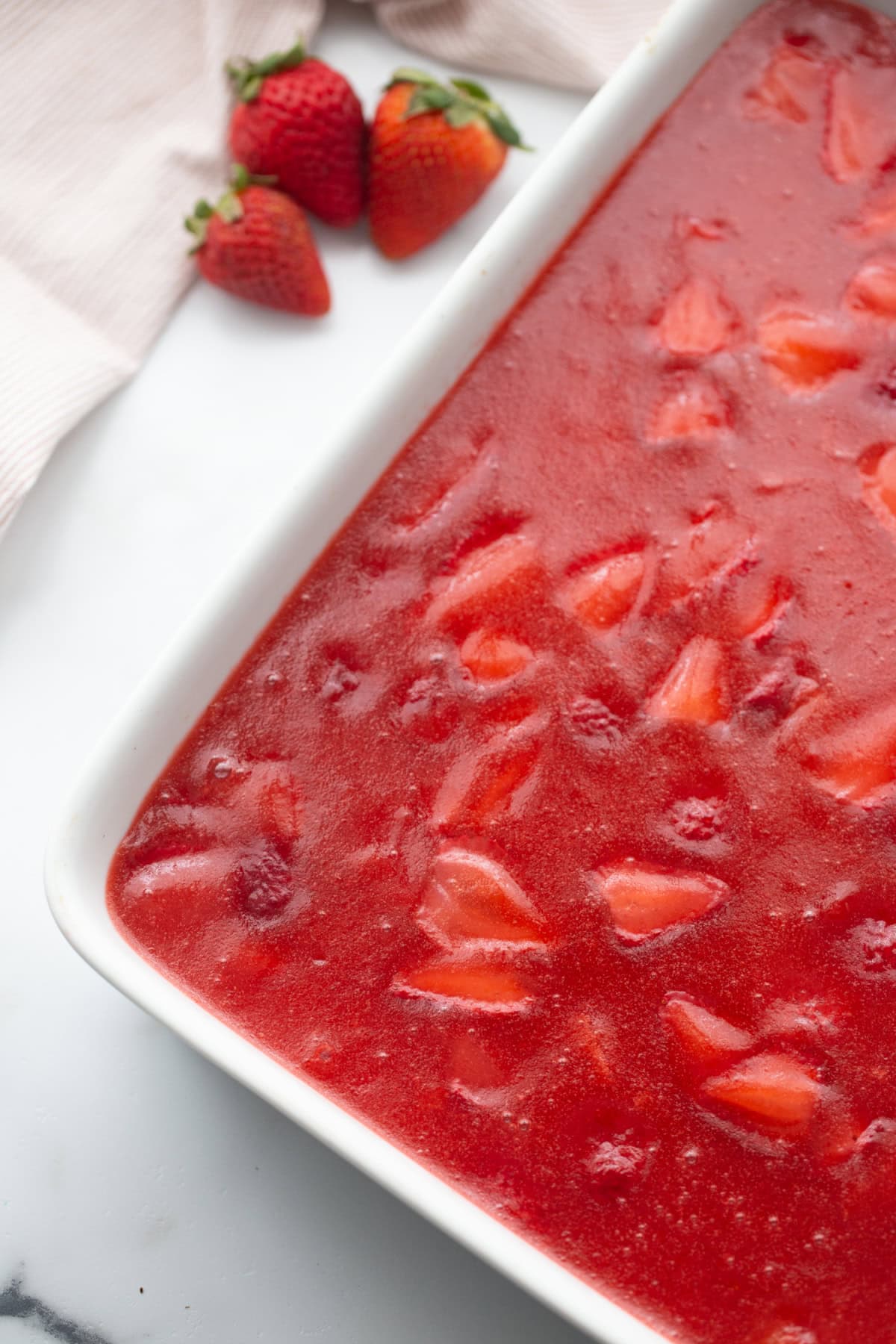 This Old Fashioned Strawberry Pretzel Salad is a timeless favorite! 🍓 Made with a buttery pretzel crust, fluffy cream cheese layer and a homemade strawberry topping with real strawberries, it's the perfect make-ahead dessert for holidays, potlucks and summer parties. Save this classic recipe! #strawberrypretzelsalad #strawberrydessert #potluckrecipes #summerdesserts #vintagerecipes old fashioned strawberry pretzel salad in serving dish