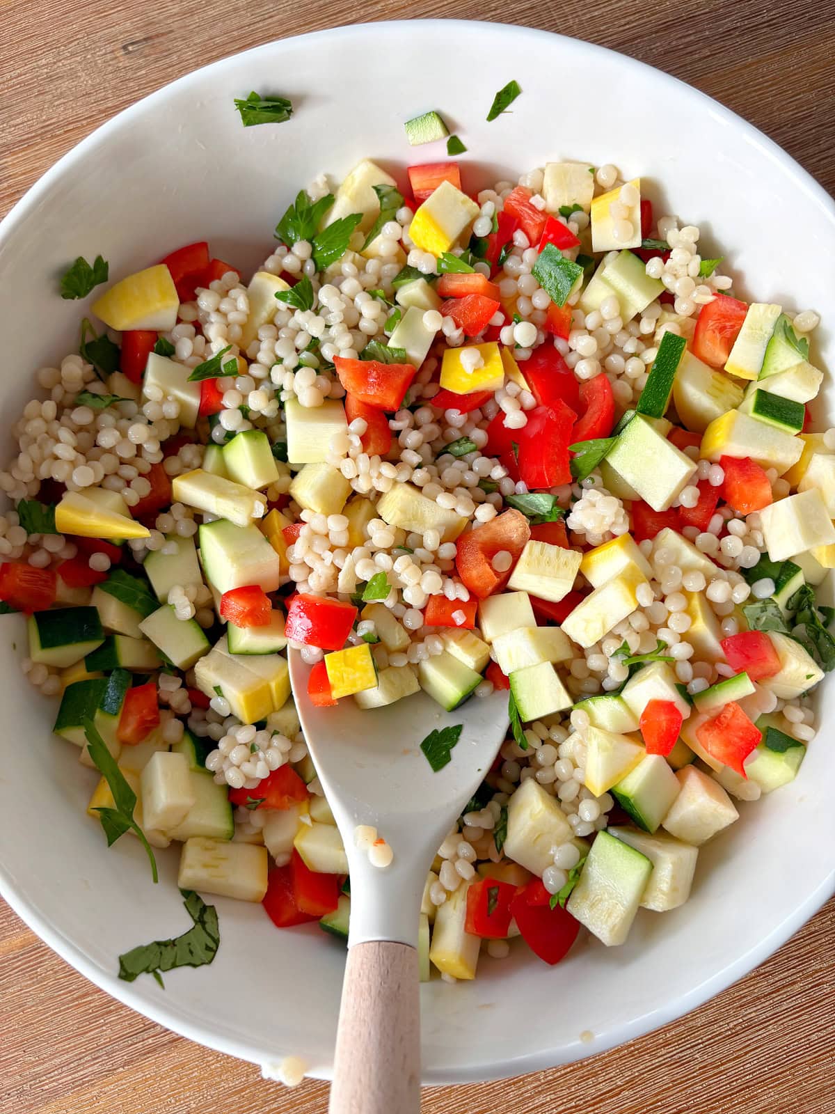 bowl of summer couscous salad with serving spoon