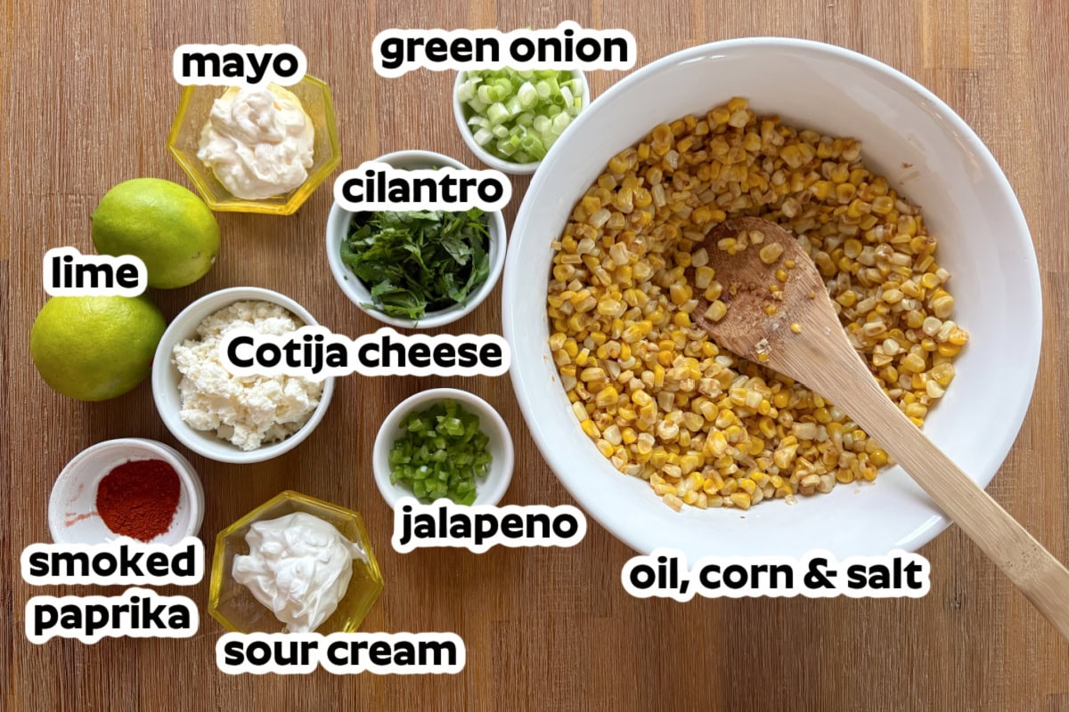 This easy Mexican Street Corn Salad combines lightly charred corn with Cotija cheese, cilantro, green onions and a creamy lime dressing. Make it with fresh, frozen or canned corn for an easy summer side dish that's perfect for tacos, BBQs, potlucks and cookouts. ingredients displayed for making mexican street corn salad