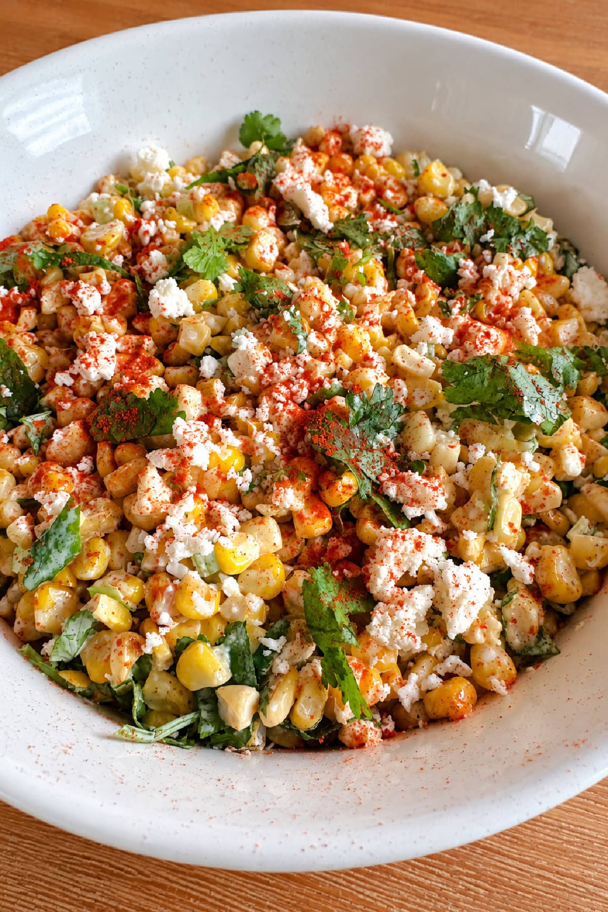 This easy Mexican Street Corn Salad combines lightly charred corn with Cotija cheese, cilantro, green onions and a creamy lime dressing. Make it with fresh, frozen or canned corn for an easy summer side dish that's perfect for tacos, BBQs, potlucks and cookouts. mexican street corn salad in bowl