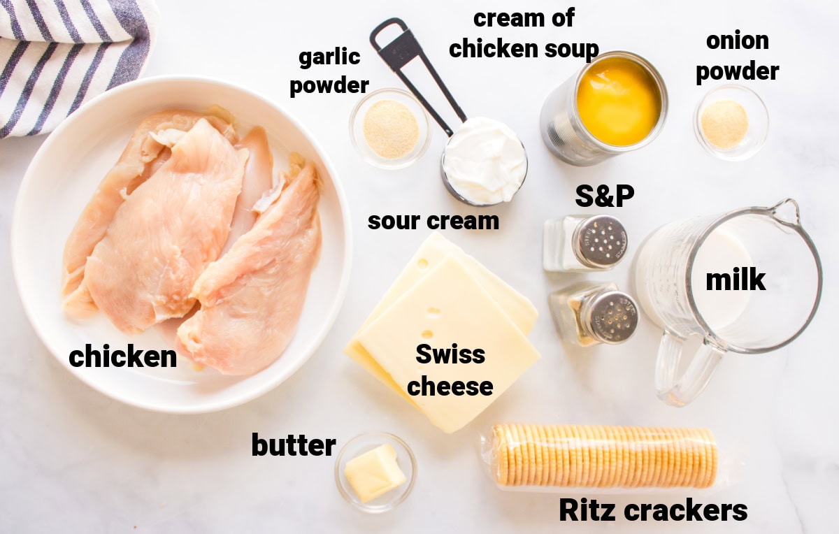 This easy Swiss Cheese Chicken recipe is the perfect comfort-food dinner! Chicken breasts are topped with Swiss cheese, a creamy sauce and buttery Ritz cracker crumbs, then baked until tender and golden. An easy 45-minute chicken dinner that's great for busy weeknights. ingredients displayed for making swiss cheese chicken