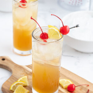 whiskey sour punch decorated with cherries and sliced lemons