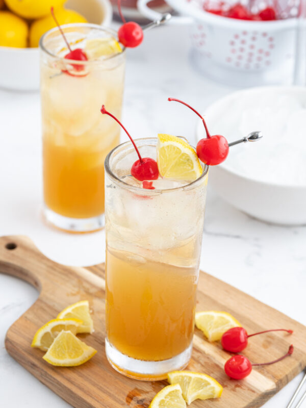 whiskey sour punch decorated with cherries and sliced lemons