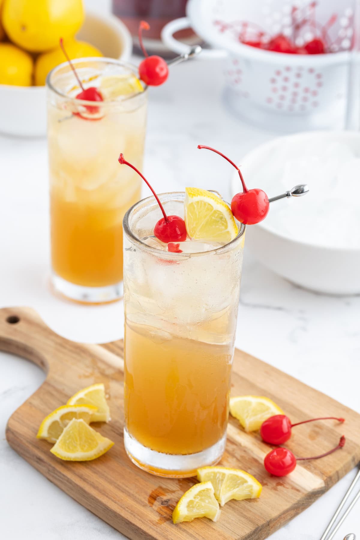 whiskey sour punch decorated with cherries and sliced lemons