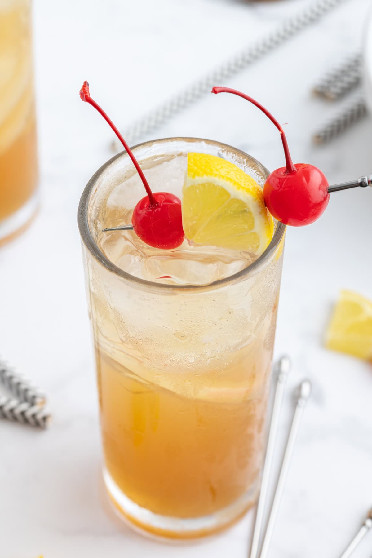 whiskey sour punch glass garnished with cherries and lemon